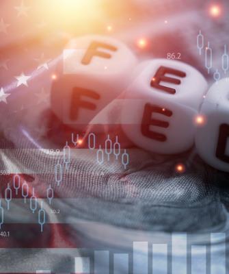 FED, σημαία ΗΠΑ, και διάγραμμα της χρηματιστηριακής αγοράς