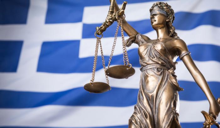 Η Θέμιδα μπροστά στην ελληνική σημαία Άγαλμα Θέμιδος Ελλάδα
