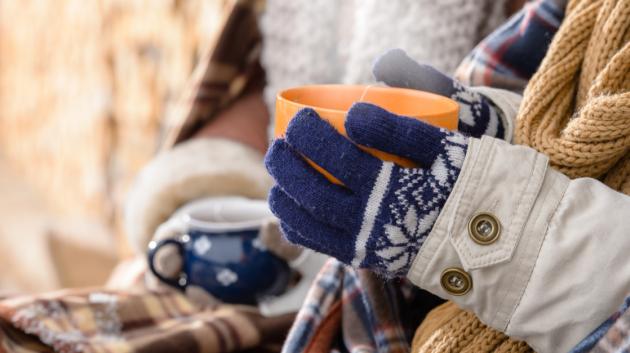 Χέρια με γάντια και φλιτζάνι